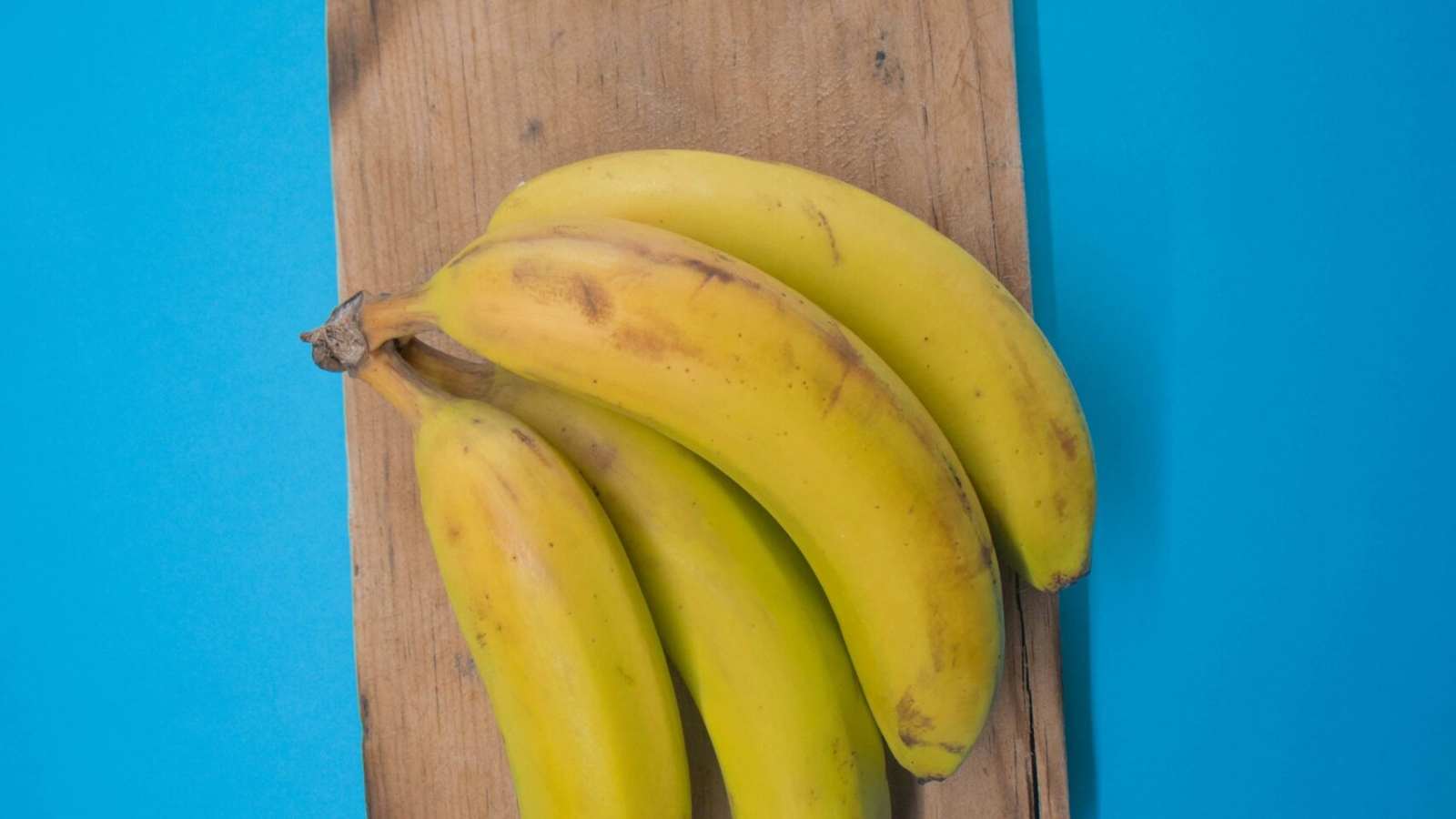 a bunch of bananas sitting on top of a wooden cutting board